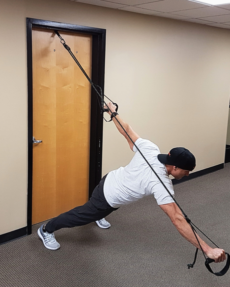 Fit Man working out with a NOSSK Cyclone Trainer anchored from an office door