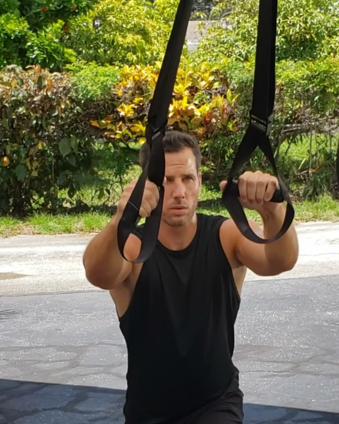 Middle aged man working out holding the handles of a NOSSK TNT Suspension Fitness Trainer